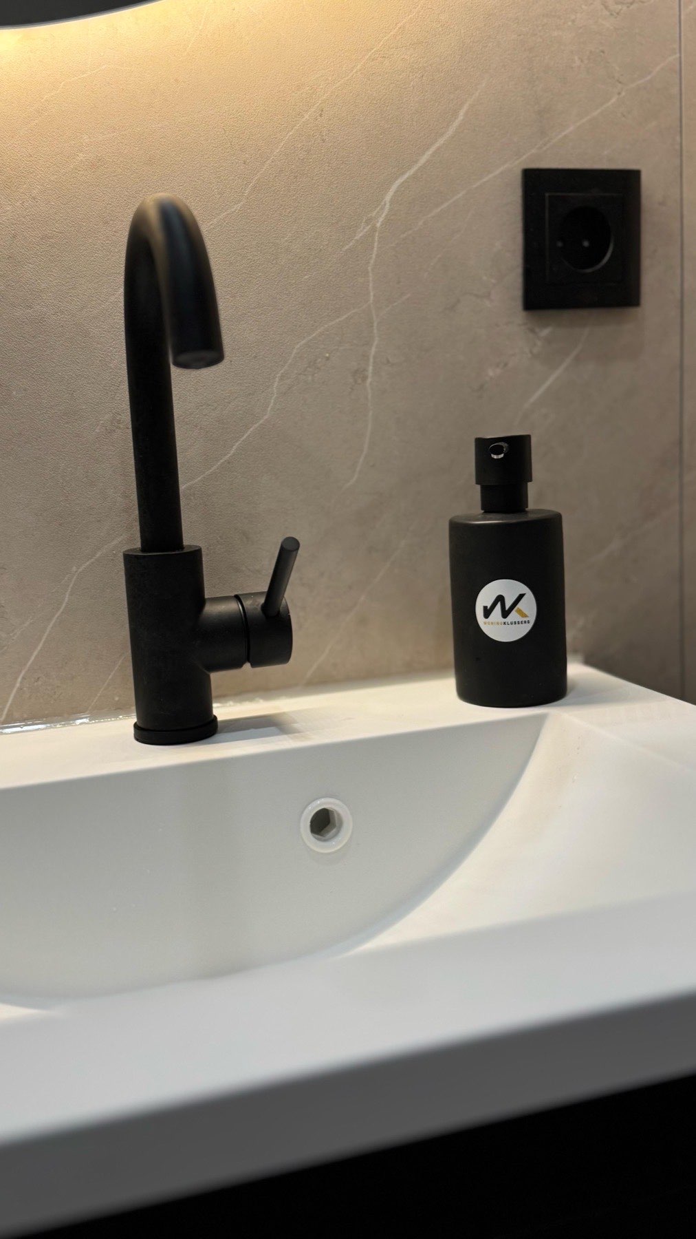 Detail van zwarte kraan en zeepdispenser