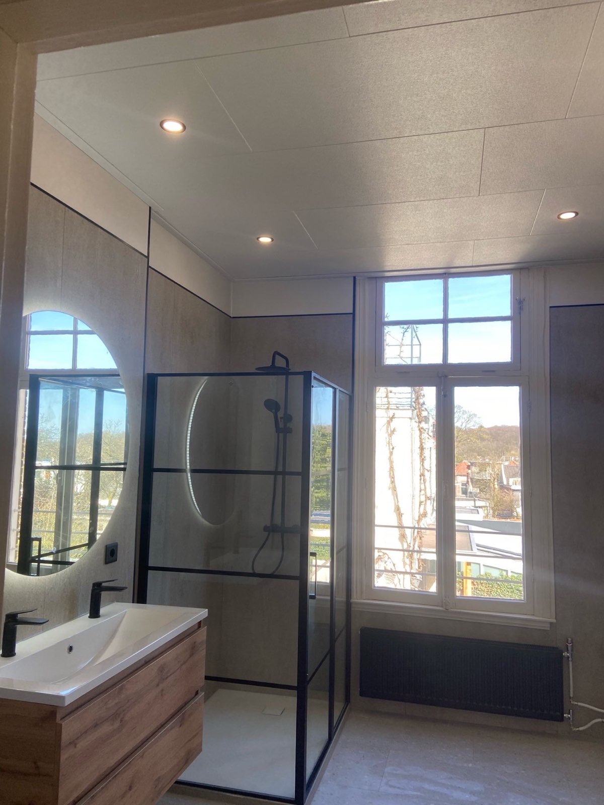 Badkamer met hoog raam en douchecabine